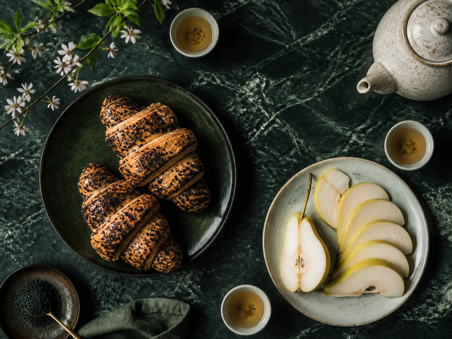 Black sesame pastries and pears on green stone